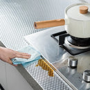 Adesivo de alumínio para cozinha demonstrando resistência à gordura e facilidade de limpeza.