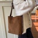 Mujer usando bolso bucket gamuza al hombro con look coreano casual sweater beige