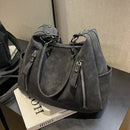 Detalle de cremalleras frontales y acabado mate gamuzado en bolso hobo de cuero PU