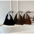 Bolso de gamuza mujer hombro en tres tonos sobre estante minimalista