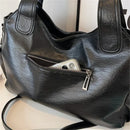 Detalle de remaches plateados y doble cierre metálico en bolso hobo cuero PU