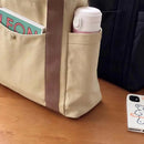 Bolso multibolsillos organizando libro termo y accesorios para el trabajo