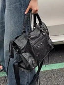 Bolso motociclista negro con flecos largos y silueta silla de montar estilo urbano