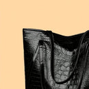 Detalle de textura cocodrilo en relieve sobre cuero PU brillante de bolso tote elegante