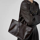 Mujer usando bolso tote de cuero encerado al hombro en look ejecutivo elegante