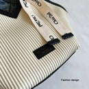 Detalle textura plisada vertical y cinta canvas con logo en bolso tote diamante