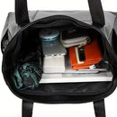Bolso tote con notebook apoyado mostrando capacidad amplia para uso laboral