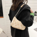Cartera baguette blanca con flores en relieve y cadena plateada modelo