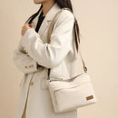 Cartera bandolera de nylon blanca cruzada usada por mujer con blazer