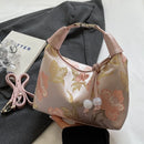 Cartera bordada estilo chino rosa con flores doradas y dije de cuentas