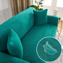 Funda jacquard para sofá verde teal con textura de hojas y look sofisticado en living