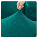 Detalle de textura jacquard con relieve de hojas en funda para sofá verde teal premium