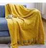 Manta boho para sofá em tricô em uso na sala, criando aconchego e cor