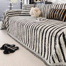 Manta cubre sofá rayas blanco y negro jacquard con flecos en living moderno con actitud