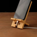 Soporte de celular de bambú para escritorio con ranura para cargar mientras usás